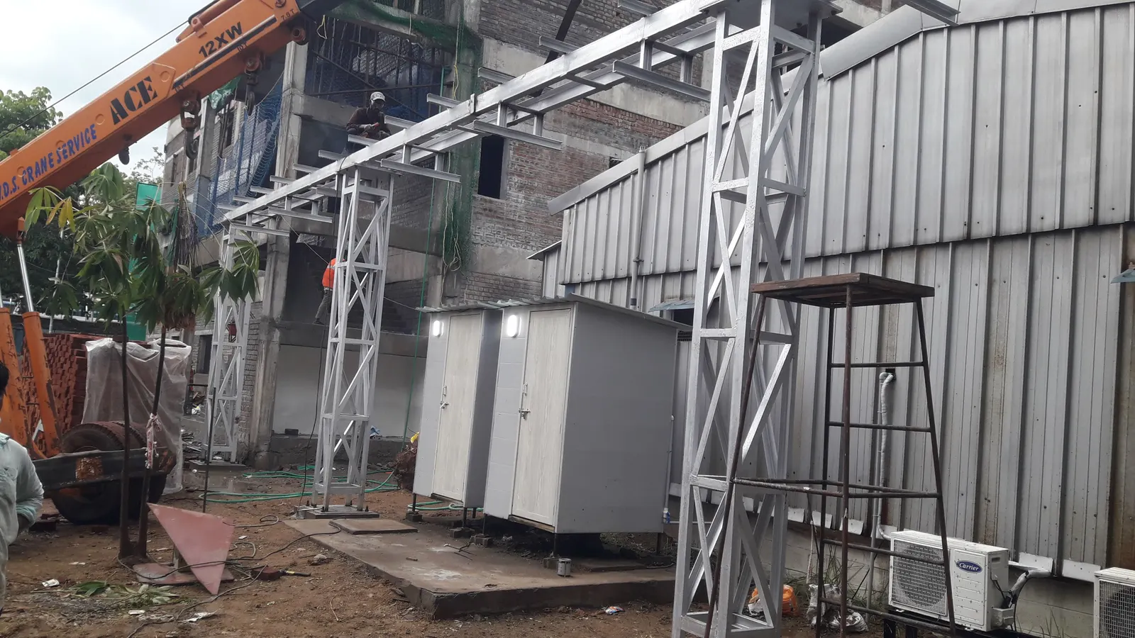 Structural steel framework being erected on site with crane support